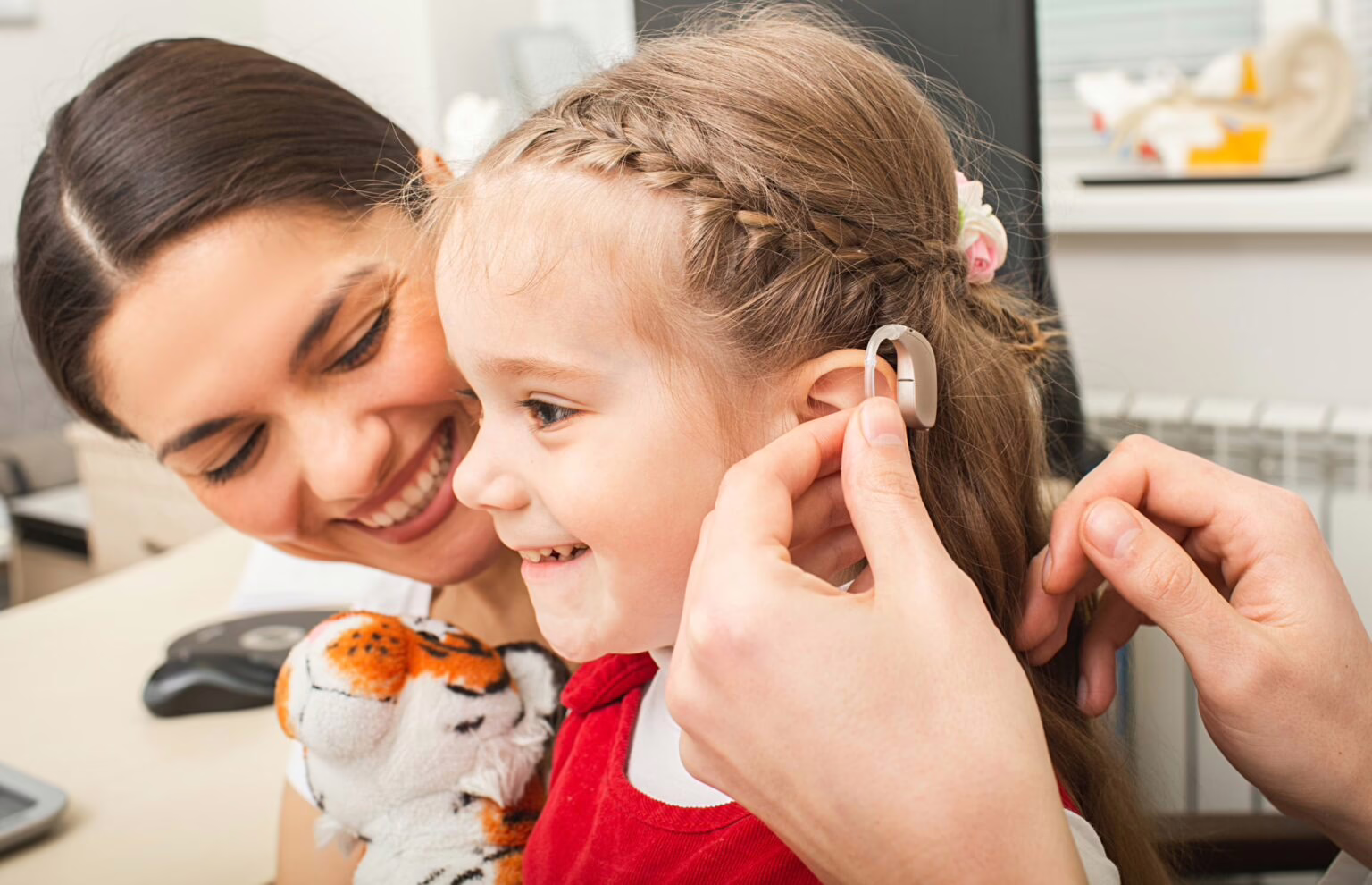 Pediatric Child Hearing Aid Fitting Audiologist fitting a child with a new hearing aid
