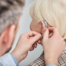 Woman getting fitted for a hearing aid by hear audiologist.