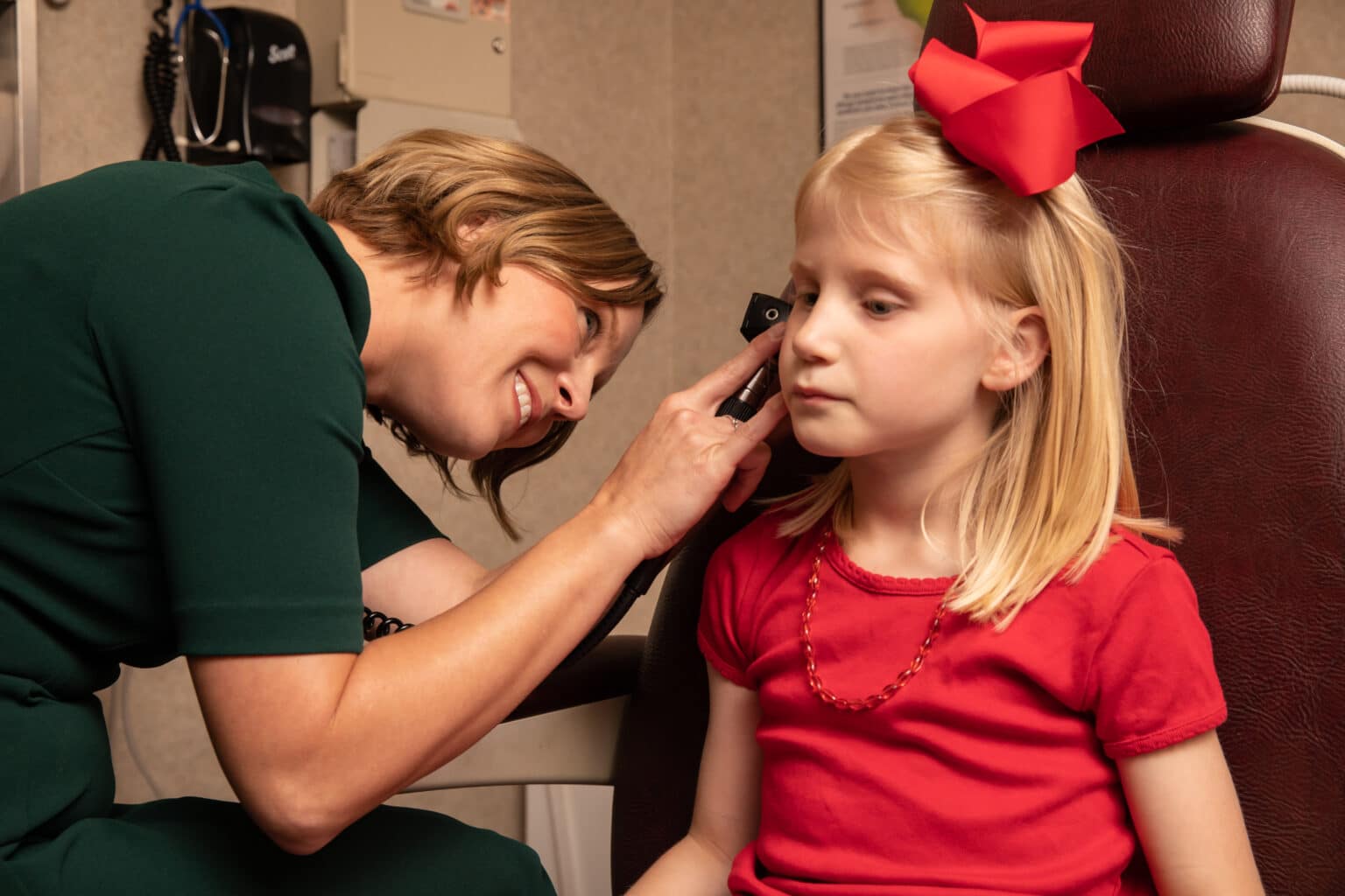 pediatric-ear-infection-symptoms ENT examining a pediatric patients ear for signs of infection