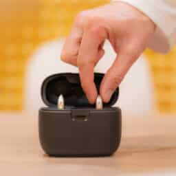Person putting hearing aids in a case