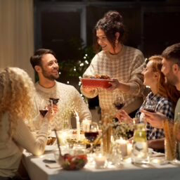 Happy friends having dinner at home