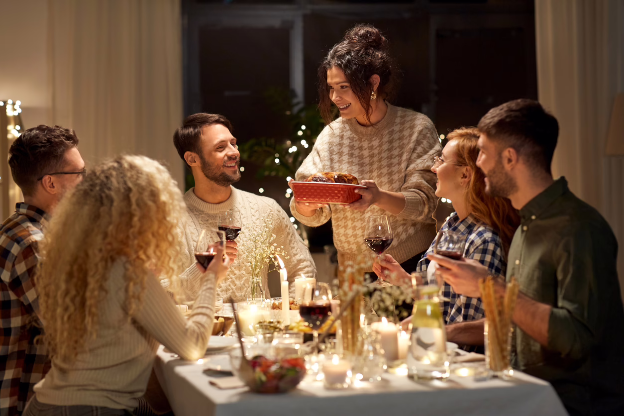 Happy friends having dinner at home.