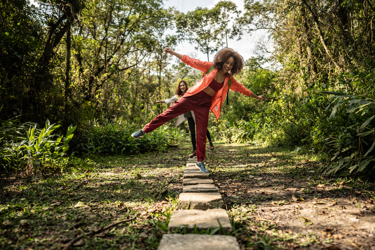 Young women walking on stones during hiking in the forest.