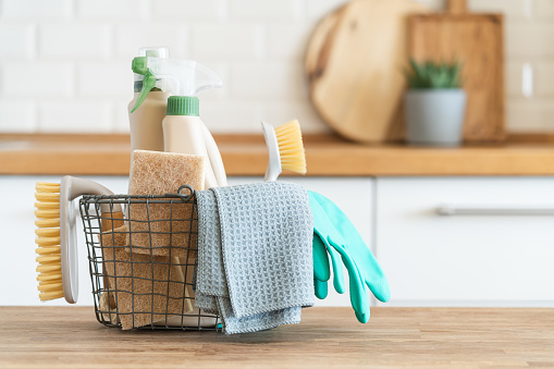 Basket of cleaning supplies sitting on a counter.